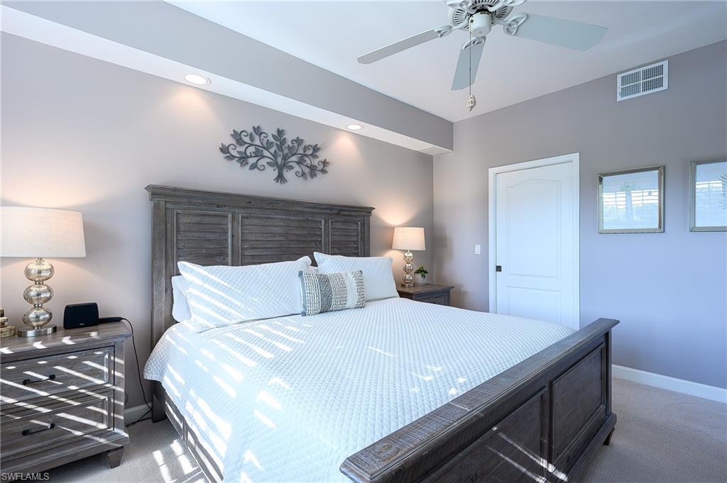 2371 Ravenna Boulevard, Unit 101 Naples, FL 34109 - Photo 13 of 44 Carpeted bedroom with ceiling fan