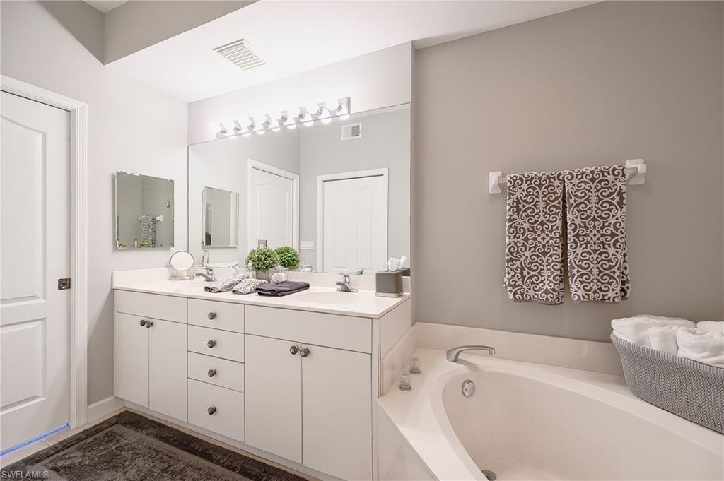 2371 Ravenna Boulevard, Unit 101 Naples, FL 34109 - Photo 14 of 44 Bathroom with a bathtub and vanity
