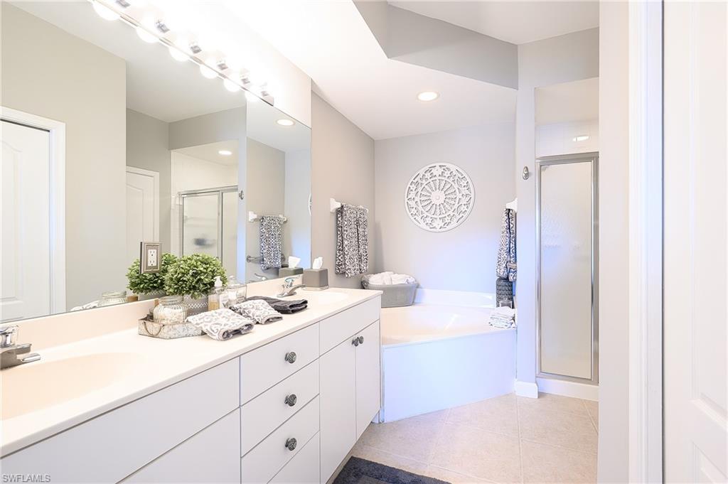 2371 Ravenna Boulevard, Unit 101 Naples, FL 34109 - Photo 16 of 44 Bathroom featuring tile patterned flooring, independent shower and bath, and vanity