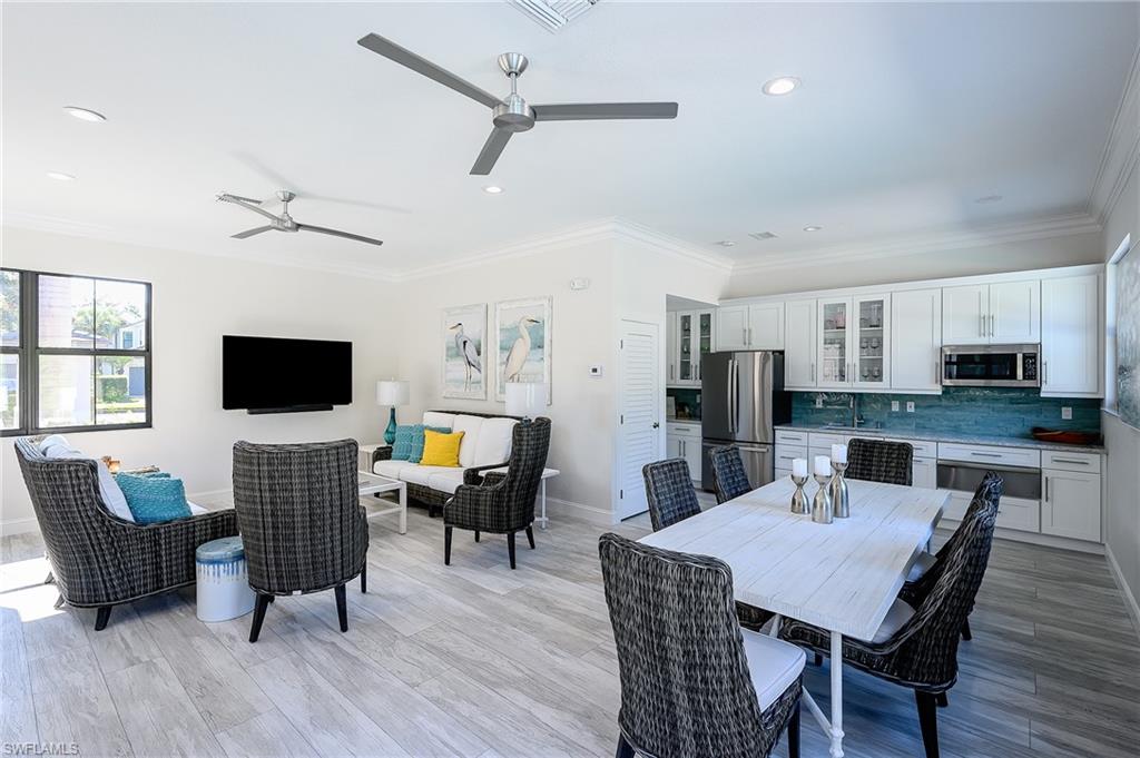 2371 Ravenna Boulevard, Unit 101 Naples, FL 34109 - Photo 33 of 44 Dining area featuring light hardwood / wood-style flooring, crown molding, and sink