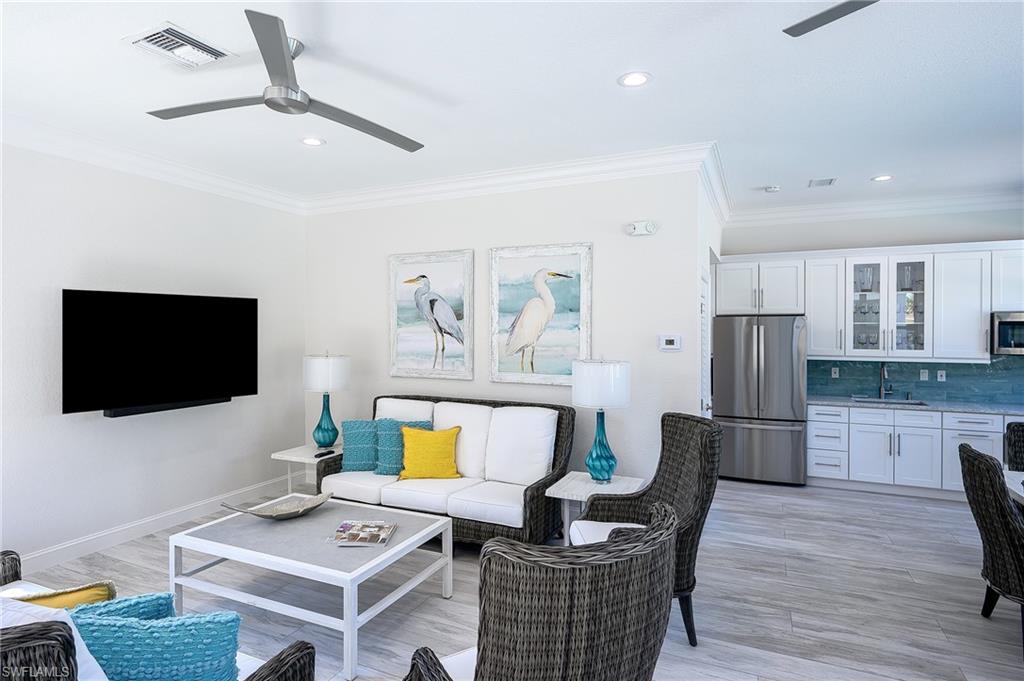 2371 Ravenna Boulevard, Unit 101 Naples, FL 34109 - Photo 35 of 44 Living room with ceiling fan, ornamental molding, light wood-type flooring, and sink