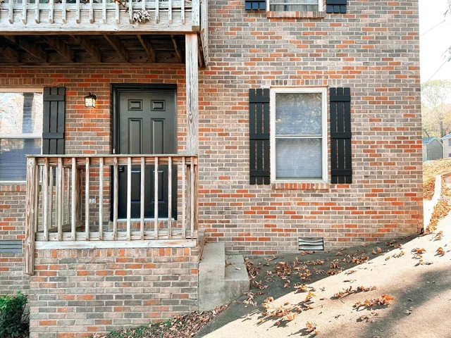 a view of a brick house with wooden fence