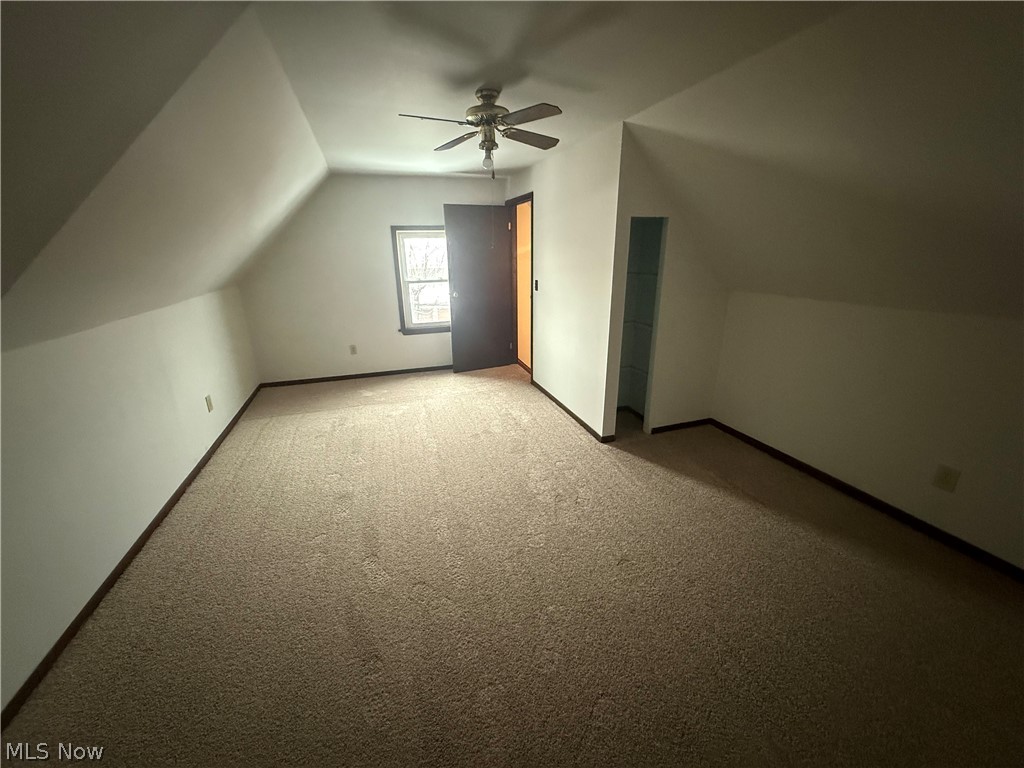 3612 Riverside Avenue Cleveland, OH 44109 - Photo 22 of 22 Carpeted room featuring sloped ceilings, a ceiling fan, a window with exterior visibility, and a built-in alcove