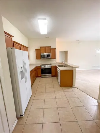 a kitchen with stainless steel appliances a stove a refrigerator a sink a microwave and cabinets