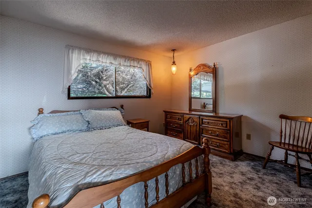 a bedroom with a bed table and chair