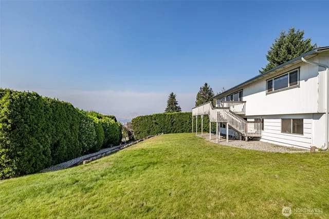 a view of a house with a yard and potted plants