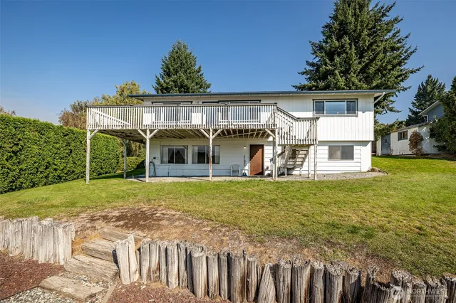 a view of a house with backyard and sitting area