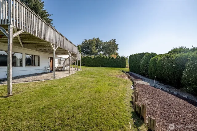 a view of house with backyard and sitting area