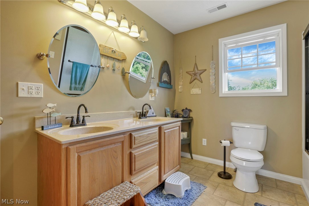 3483 Cooper Road Cumberland, OH 43732 - Photo 20 of 50 Bathroom with a healthy amount of sunlight, tile flooring, toilet, and double sink vanity