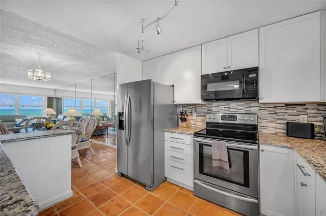 a kitchen with stainless steel appliances a stove refrigerator sink and microwave