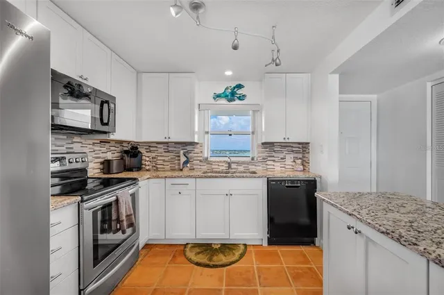 a kitchen with granite countertop stainless steel appliances and wooden cabinets