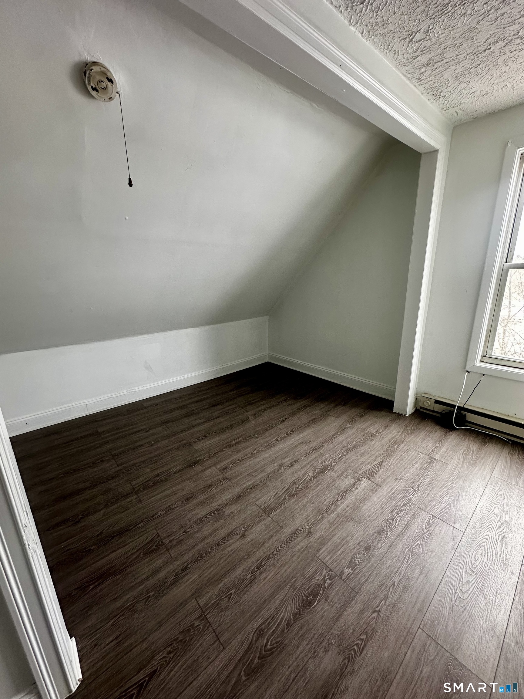 147 Helen Street, Unit 3 Bridgeport, CT 06608 - Photo 5 of 5 a view of an empty room with wooden floor and a window