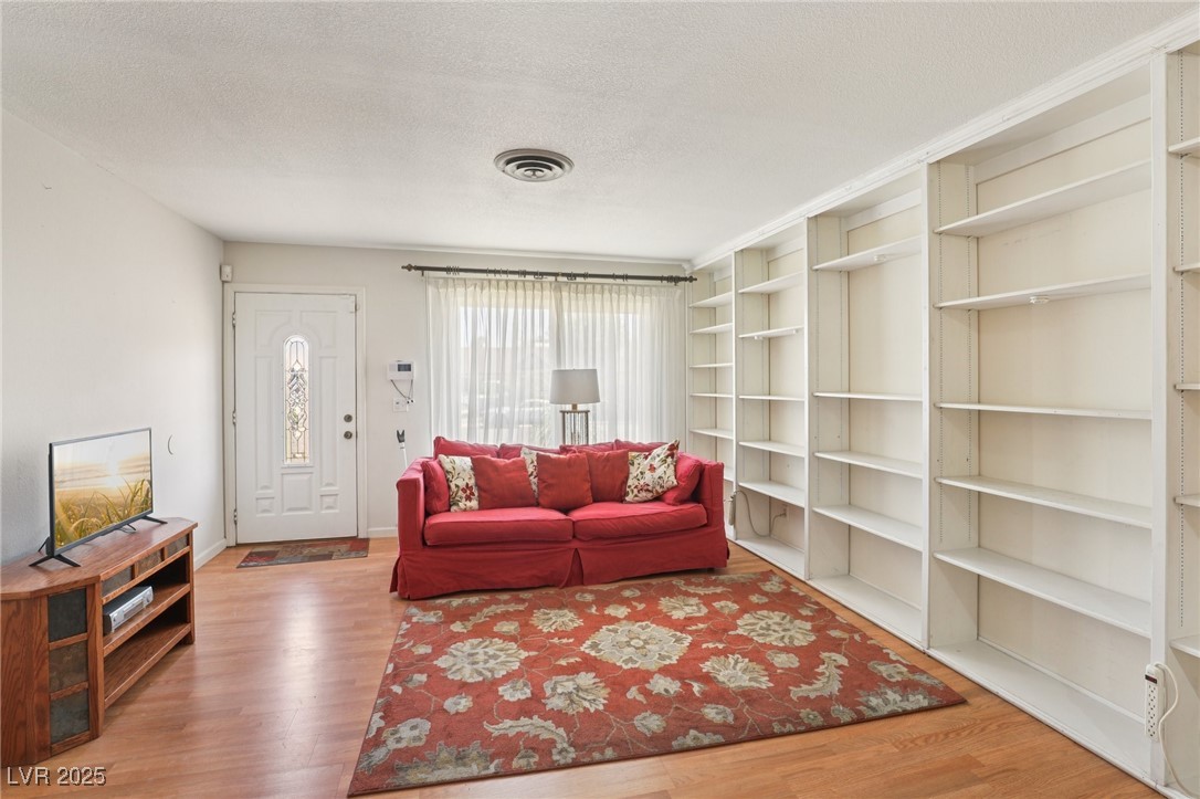 4027 Maple Hill Road Las Vegas, NV 89115 - Photo 5 of 46 Living room with wood finished floors and a textured ceiling