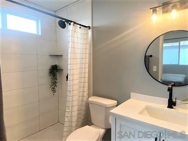 13360 Floral Avenue Poway, CA 92064 - Photo 23 of 37 a bathroom with a toilet a sink and a shower curtain