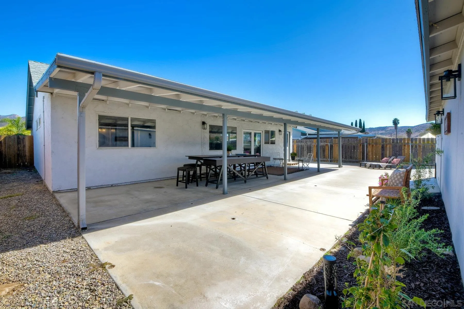 13360 Floral Avenue Poway, CA 92064 - Photo 27 of 37 a view of a patio with dining table and chairs with wooden fence