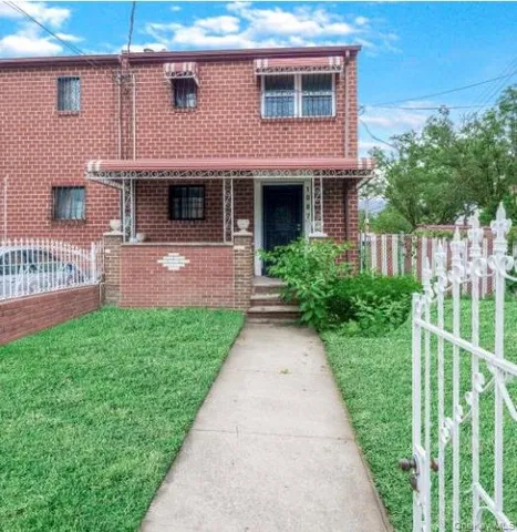 a front view of a house with a yard and potted plants