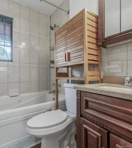 a bathroom with a granite countertop toilet sink and bathtub