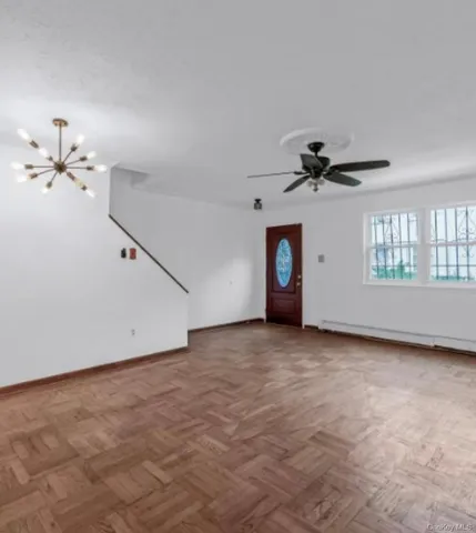 a view of a livingroom with a ceiling fan and window