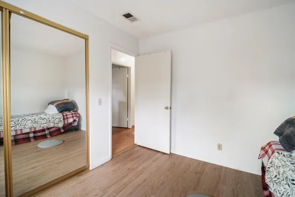 a view of a bedroom with wooden floor