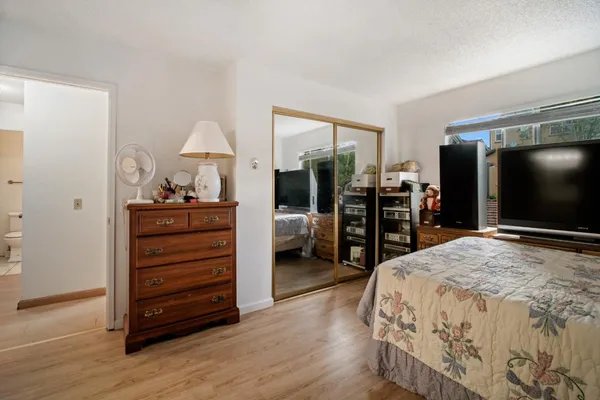 a bedroom with a bed and a flat tv screen on desk