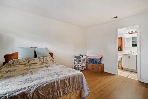 a bedroom with a bed and wooden floor
