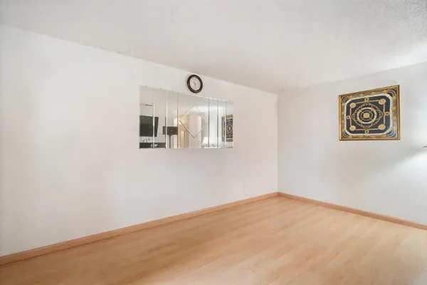 an empty room with large window and mirror