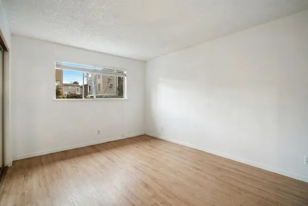 a view of an empty room with window and bathroom
