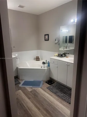 a bathroom with a bathtub sink and mirror