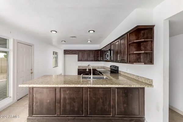 a kitchen with stainless steel appliances granite countertop a stove a sink dishwasher and a refrigerator