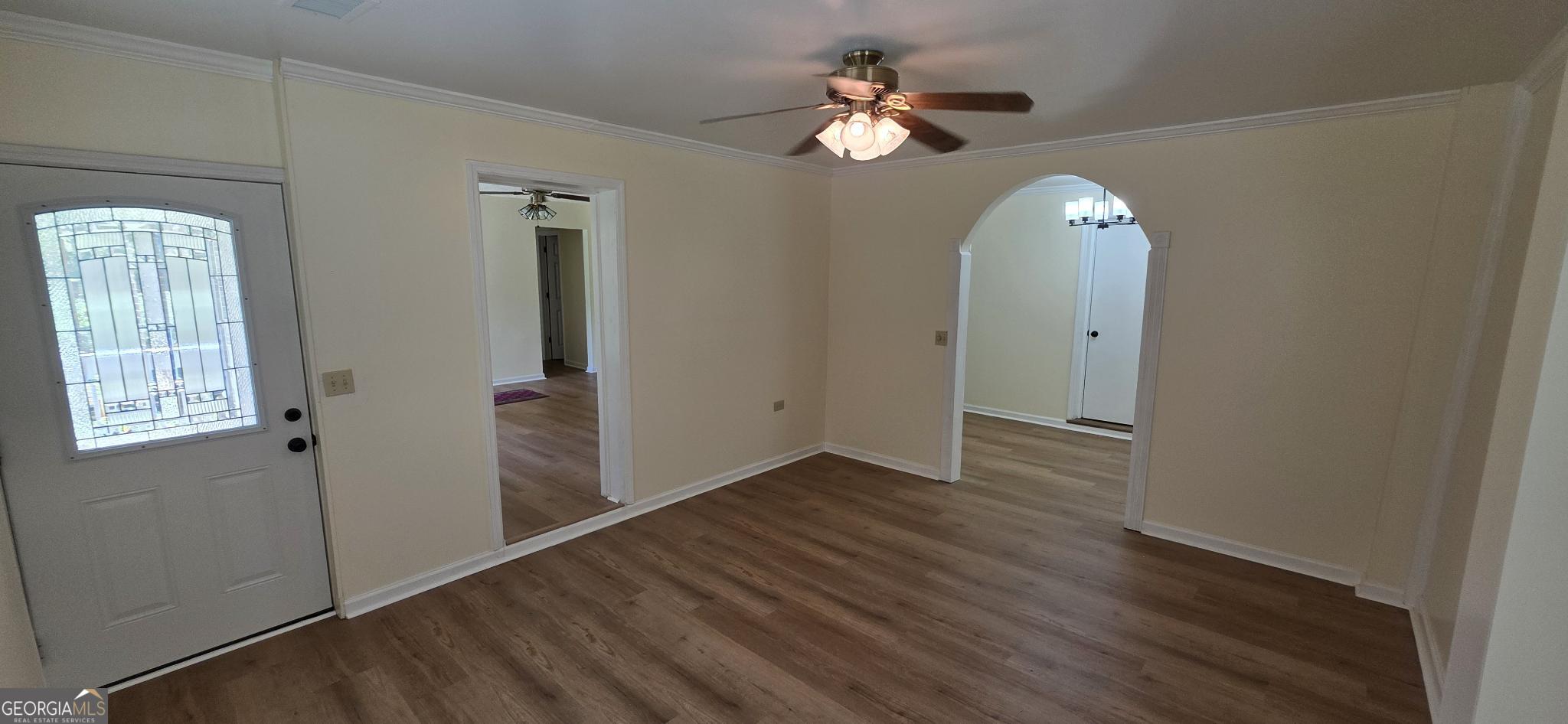 657 Tom McKinley Road Thomaston, GA 30286 - Photo 14 of 33 an empty room with wooden floor chandelier fan and windows