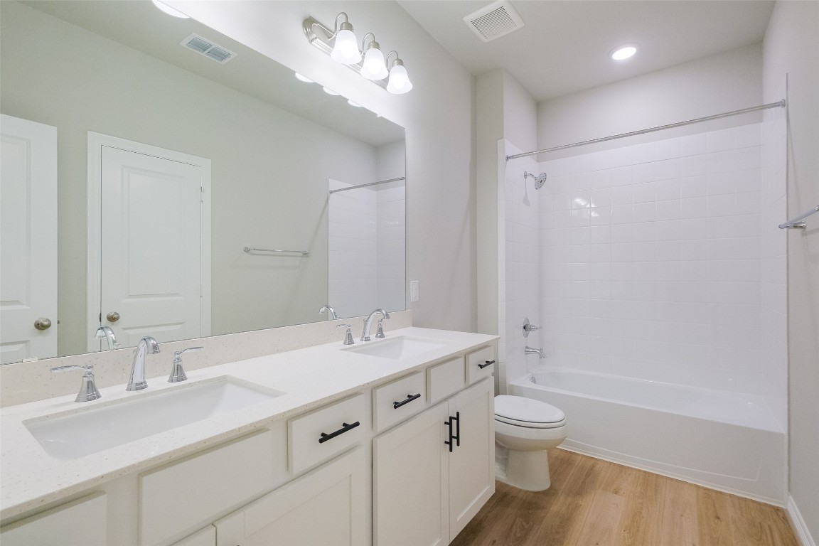 6434 New York Street Houston, TX 77021 - Photo 19 of 27 a bathroom with a granite countertop sink toilet a large mirror a shower and a bathtub