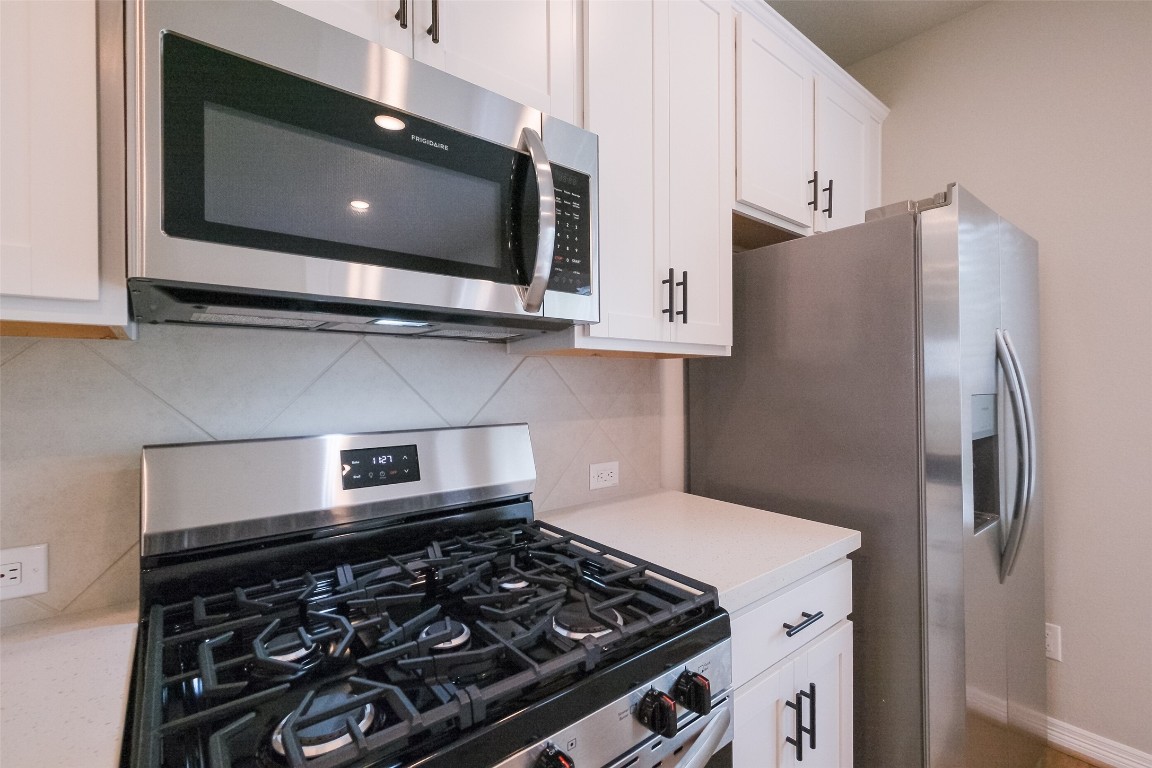6434 New York Street Houston, TX 77021 - Photo 9 of 27 a kitchen with stainless steel appliances granite countertop a stove and a refrigerator