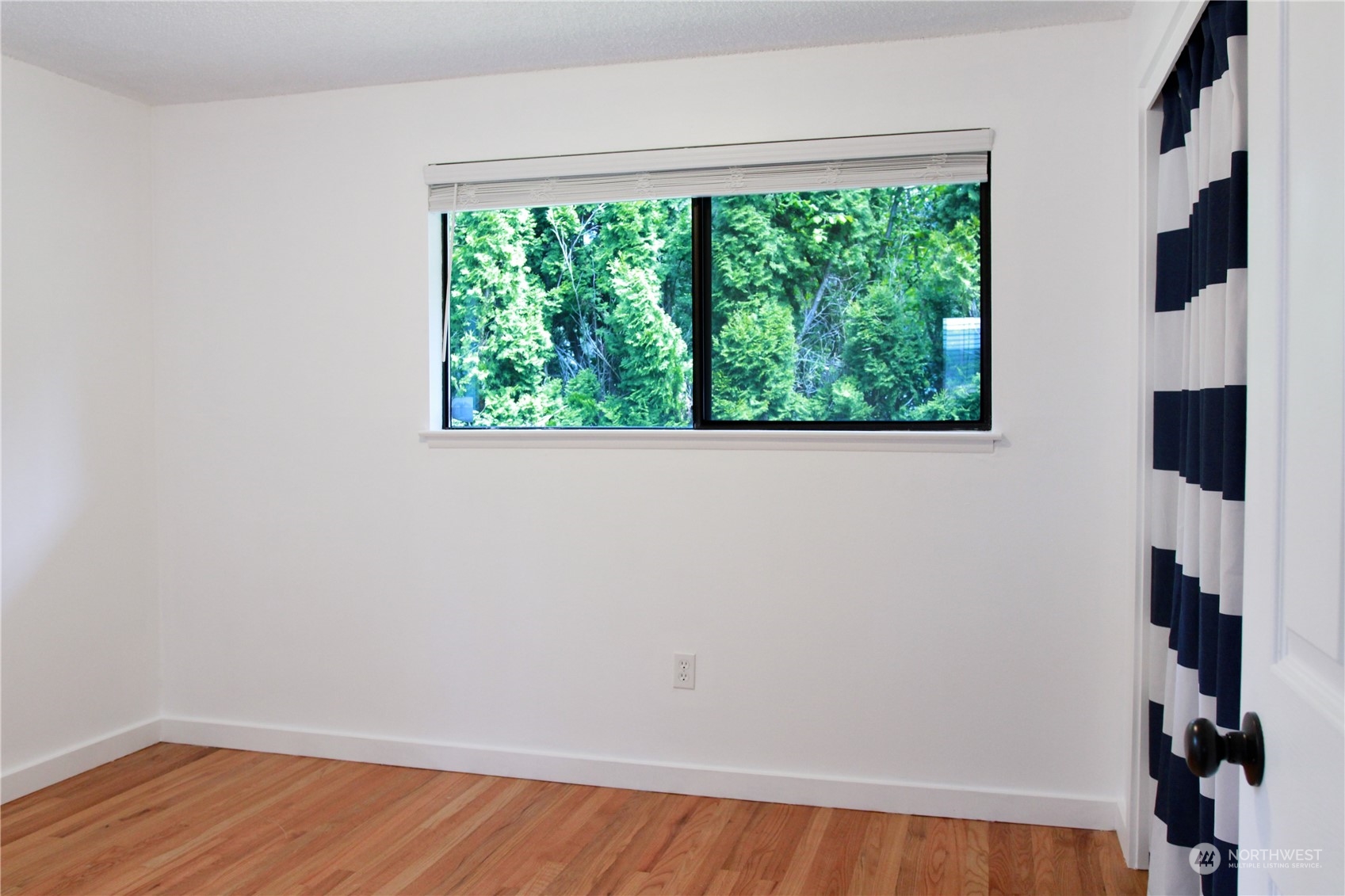 18817 Southeast 134th Street Renton, WA 98059 - Photo 12 of 27 an empty room with wooden floor and windows