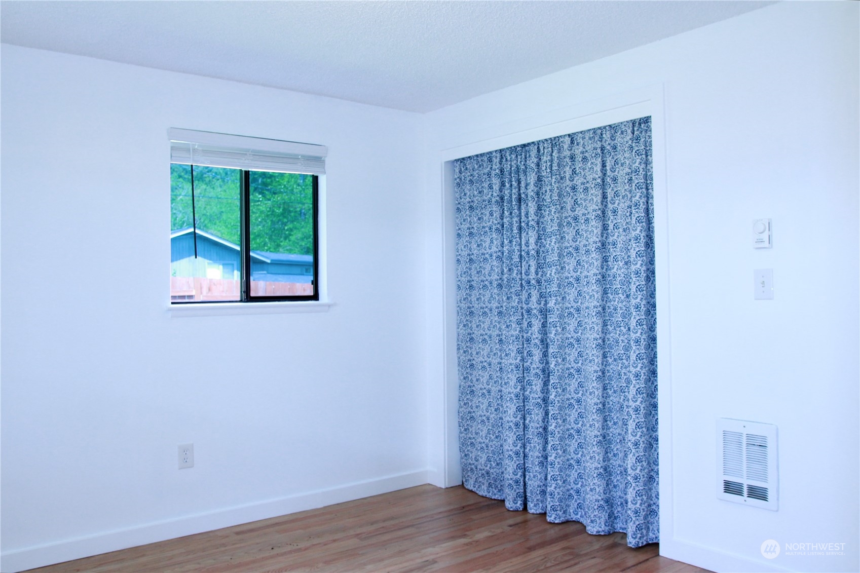 18817 Southeast 134th Street Renton, WA 98059 - Photo 8 of 27 a view of an empty room with wooden floor and a window