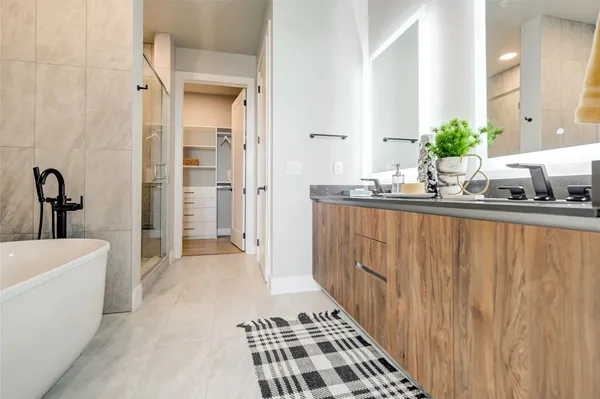 a bathroom with a double vanity sink a mirror and a bathtub