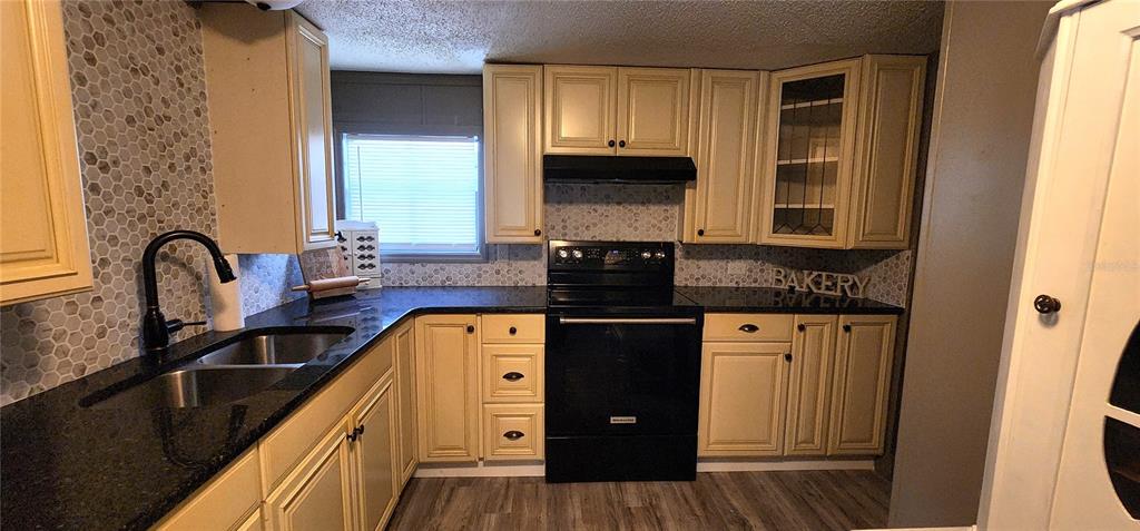 19865 Southwest 5th Place Dunnellon, FL 34431 - Photo 36 of 78 a kitchen with granite countertop a stove a sink and a microwave