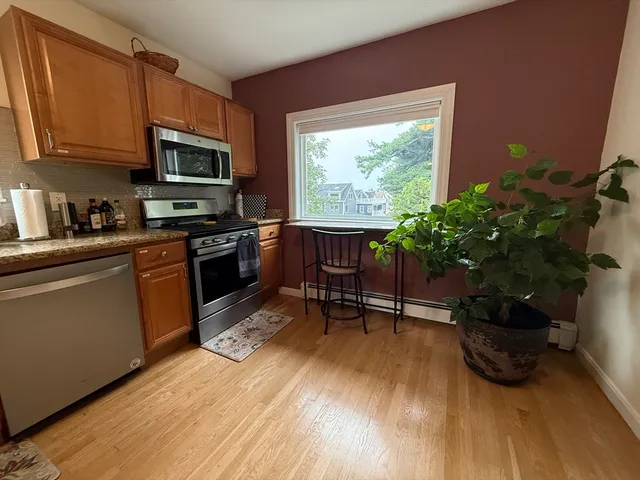 a kitchen with stainless steel appliances granite countertop a stove a microwave a sink and cabinets