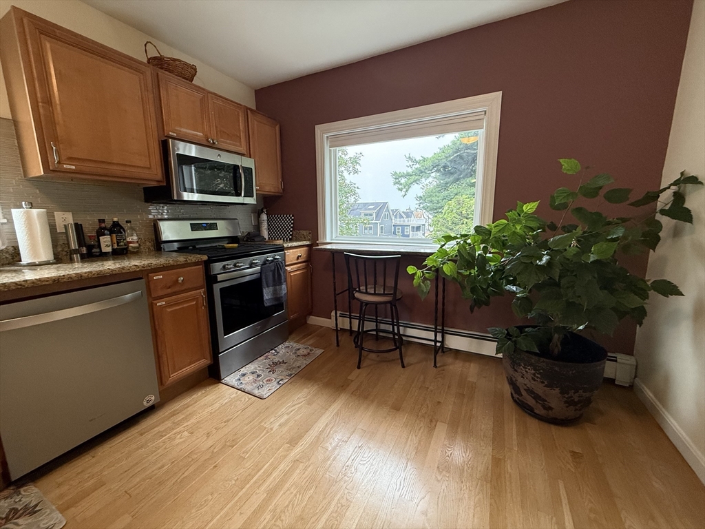 159 Walnut Street, Unit 2 Somerville, MA 02145 - Photo 3 of 10 a kitchen with stainless steel appliances granite countertop a stove a microwave a sink and cabinets