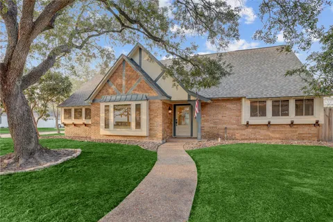 a front view of a house with a yard and trees