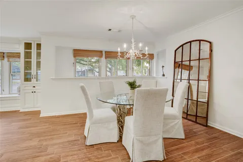 a view of a dining room with furniture a chandelier and wooden floor