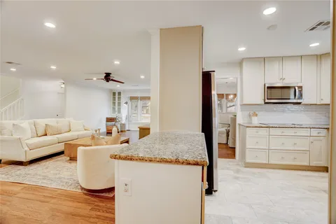 a large living room with stainless steel appliances granite countertop furniture and a kitchen view