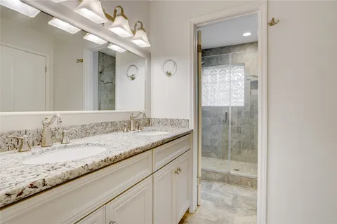 a bathroom with a granite countertop sink mirror and double