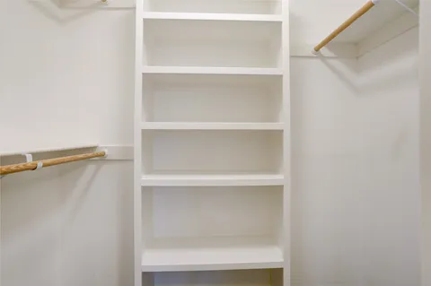 a view of walk in closet with empty racks