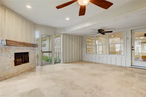 a view of an empty room with a ceiling fan and window