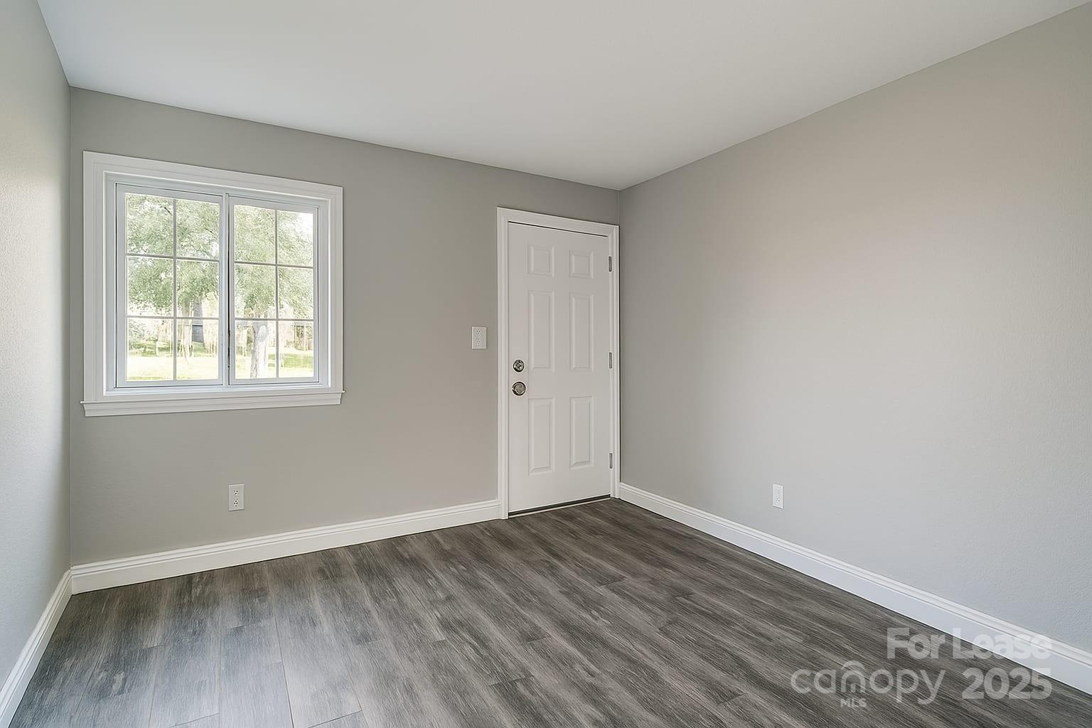 5821 Hunting Ridge Lane, Unit F Charlotte, NC 28212 - Photo 12 of 16 an empty room with wooden floor and windows