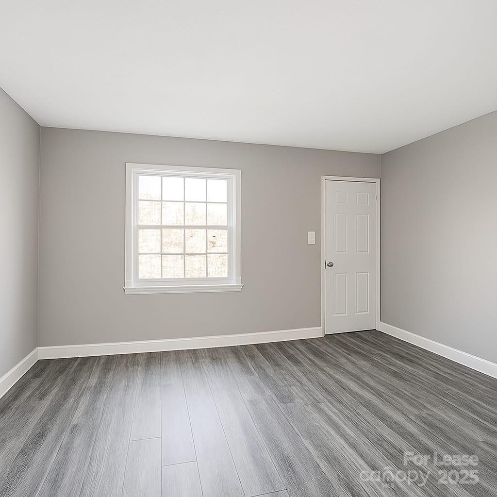 5821 Hunting Ridge Lane, Unit F Charlotte, NC 28212 - Photo 14 of 16 an empty room with wooden floor and windows