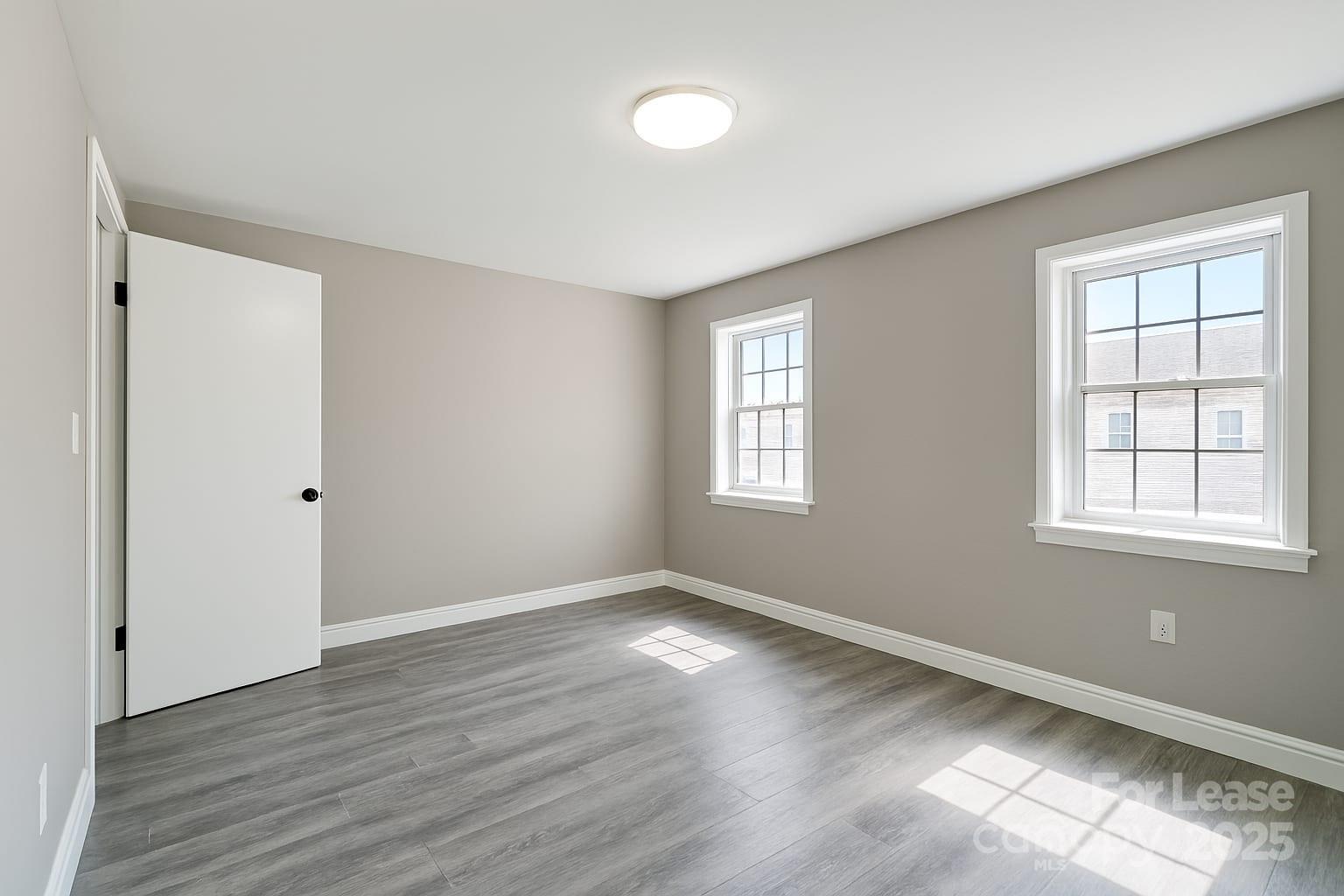 5821 Hunting Ridge Lane, Unit F Charlotte, NC 28212 - Photo 3 of 16 a view of an empty room with wooden floor and a window