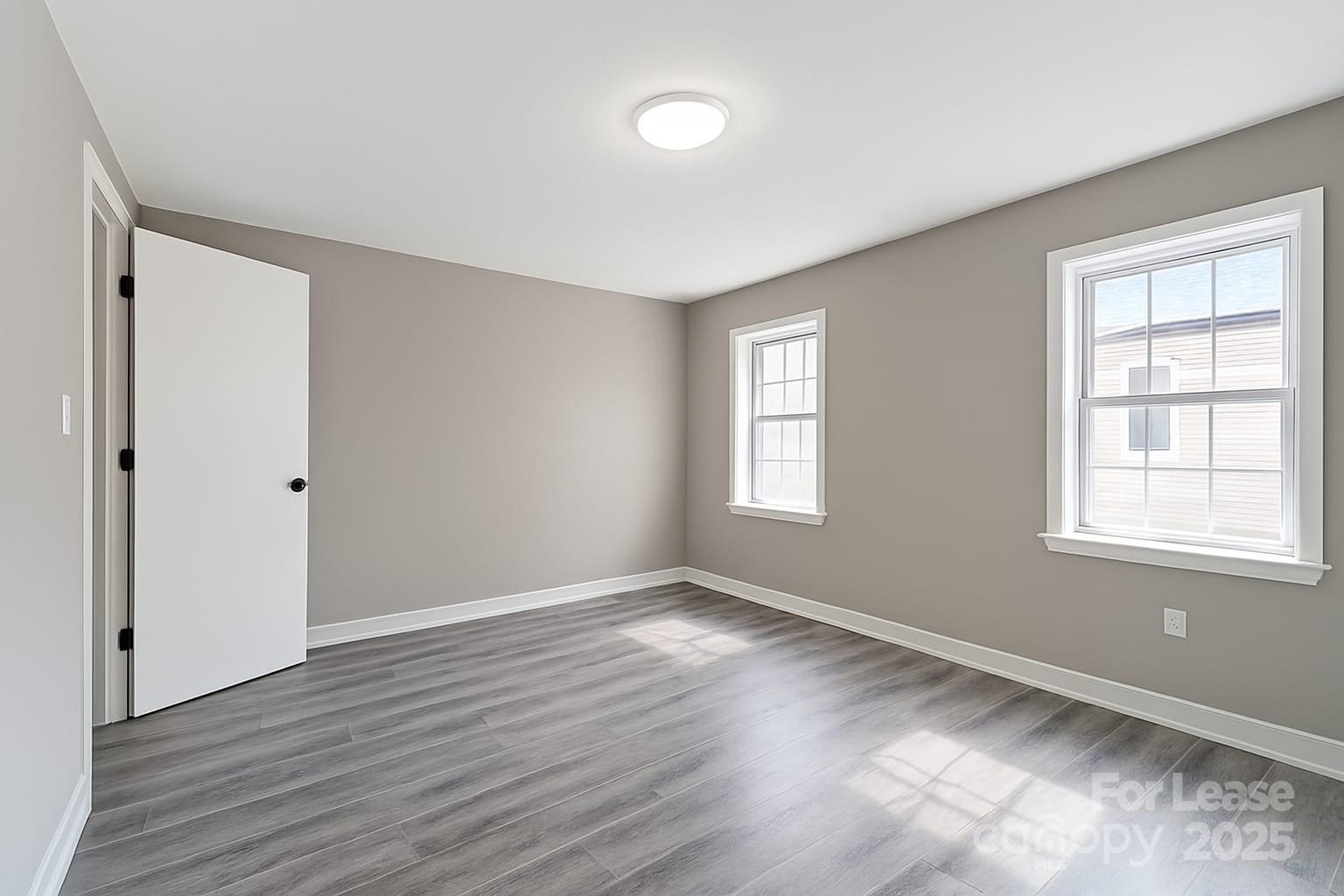 5821 Hunting Ridge Lane, Unit F Charlotte, NC 28212 - Photo 10 of 16 a view of an empty room with wooden floor and a window