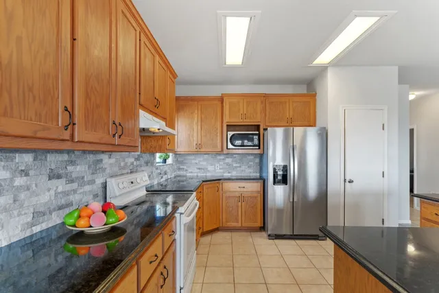 a kitchen with stainless steel appliances granite countertop a refrigerator and a sink