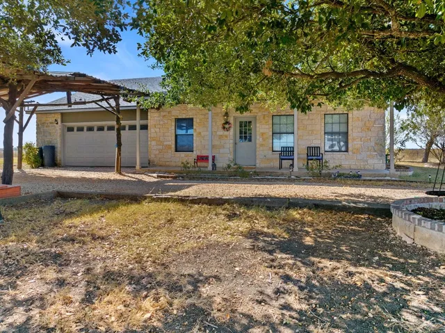 a view of a house with a big yard and a large trees